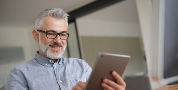 Älterer Mann arbeitet am Tablet