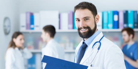 Selbstbewusster Arzt mit Unterlagen im Büro